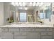 Bathroom featuring dual sinks with granite counters, large mirror, and bright vanity lighting at 4272 E Ivanhoe St, Gilbert, AZ 85295