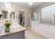 Bathroom featuring double vanity with granite counters, soaking tub, and glass block window at 4272 E Ivanhoe St, Gilbert, AZ 85295