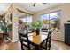 Bright dining room with a large window overlooking a patio and lush backyard landscaping and pool at 4272 E Ivanhoe St, Gilbert, AZ 85295