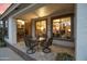 Covered patio with travertine tile, outdoor seating, and view into dining area, kitchen and living room at 4272 E Ivanhoe St, Gilbert, AZ 85295