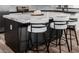 Kitchen island showcases a marble countertop, modern stools, and black cabinetry for a sleek, updated design at 441 S Dodge Dr, Chandler, AZ 85225