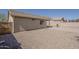 Gravel backyard featuring tan stucco exterior with a block wall in the background at 4517 N 123Rd Dr, Avondale, AZ 85392