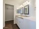 Bathroom with double sinks, granite counters, framed mirrors, and a closet on the left at 4517 N 123Rd Dr, Avondale, AZ 85392