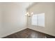 Cozy dining area with modern chandelier, wood-look floors, and bright natural light from a large window at 4517 N 123Rd Dr, Avondale, AZ 85392