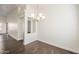 Cozy dining area with modern chandelier, wood-look floors, and an opening to the kitchen and living area at 4517 N 123Rd Dr, Avondale, AZ 85392