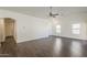 Spacious living room featuring wood-look floors, white walls, and plentiful natural light from large windows at 4517 N 123Rd Dr, Avondale, AZ 85392