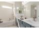 Bright bathroom featuring double sinks, ample counter space, and a separate tub at 45341 W Paraiso Ln, Maricopa, AZ 85139