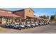 View of numerous silver golf carts lined up in front of the golf club house on a bright sunny day at 4627 E Sourwood Dr, Gilbert, AZ 85298