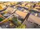 Aerial view of a desert home showing a meticulously landscaped backyard, covered patio, and lush, green grass at 4756 W Nogales Way, Eloy, AZ 85131