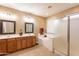 Bright bathroom featuring double sinks, a soaking tub, and a glass-enclosed shower at 4756 W Nogales Way, Eloy, AZ 85131