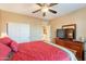 Cozy bedroom features a ceiling fan, sliding closet doors, and a TV atop a wooden dresser at 4756 W Nogales Way, Eloy, AZ 85131