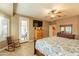 Well lit main bedroom with a ceiling fan, rocking chair, and a door leading to a balcony at 4756 W Nogales Way, Eloy, AZ 85131