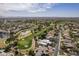 Scenic aerial view showcasing a lush golf course winding through a residential community with mountain views at 4915 N Greentree Dr, Litchfield Park, AZ 85340