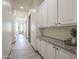 Well-lit hallway with tile flooring, white cabinets, granite countertops and storage space at 4915 N Greentree Dr, Litchfield Park, AZ 85340