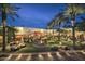 An inviting outdoor lounge area with a fire pit, palm trees, and cozy seating under string lights at 4915 N Greentree Dr, Litchfield Park, AZ 85340