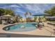 Resort-style pool with rock features, lush landscaping, basketball hoop, and ample space for outdoor enjoyment at 4915 N Greentree Dr, Litchfield Park, AZ 85340