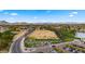 Aerial view of a well-maintained golf course with driving range and a parking lot; mountain views in the background at 4939 W Joyce Cir, Glendale, AZ 85308