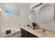 Bright bathroom featuring a dual sink vanity, updated fixtures, and a shower-tub combo at 4939 W Joyce Cir, Glendale, AZ 85308