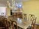 A bright dining room featuring an antler chandelier, a large wooden table with chairs, and access to the kitchen at 537 N Jay St, Chandler, AZ 85225