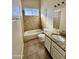 Cozy bathroom featuring tiled tub/shower, toilet, and vanity with a sink and neutral countertops at 5552 W Willow Ave, Glendale, AZ 85304