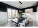 Spacious dining room with black accent wall, wainscoting, contemporary chandelier, and view of open staircase at 5601 E Monterosa St, Phoenix, AZ 85018