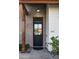 Stylish black front door with glass panels, surrounded by brick and contrasting white siding at 5601 E Monterosa St, Phoenix, AZ 85018