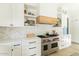 Kitchen featuring white cabinets, a custom hood, and a Wolf range at 5601 E Monterosa St, Phoenix, AZ 85018