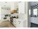 A well-designed kitchen features white cabinets, a Wolf range, and mosaic backsplash, with a view of a checkered bathroom at 5601 E Monterosa St, Phoenix, AZ 85018