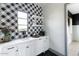 Bright kitchenette with black-and-white checkered backsplash, sleek cabinetry, quartz countertops and stainless steel appliances at 5601 E Monterosa St, Phoenix, AZ 85018