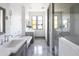 Modern bathroom featuring double sinks, soaking tub, and walk-in shower with tile surround at 5601 E Monterosa St, Phoenix, AZ 85018