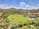 Beautiful aerial view of a large grassy park in a community surrounded by mountains at 6847 W Palo Brea Ln, Peoria, AZ 85383