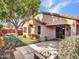 Serene backyard features a stone fire pit, lush landscaping, and a covered patio for outdoor enjoyment at 6847 W Palo Brea Ln, Peoria, AZ 85383