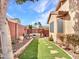 Well-maintained backyard with artificial turf, stone pathways, and colorful privacy walls, creating a tranquil oasis at 6847 W Palo Brea Ln, Peoria, AZ 85383