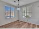 Dining area with wood-look floors, chandelier, and natural light from two windows at 6847 W Palo Brea Ln, Peoria, AZ 85383