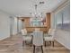 Charming dining area features a glass top table and seating for six, illuminated by a modern chandelier at 6847 W Palo Brea Ln, Peoria, AZ 85383