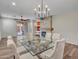 Modern dining room with glass top table, chairs, contemporary lighting, and decorative fireplace at 6847 W Palo Brea Ln, Peoria, AZ 85383