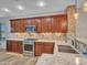 Well-lit kitchen with wood cabinetry, stainless steel appliances, decorative backsplash, and granite countertops at 6847 W Palo Brea Ln, Peoria, AZ 85383