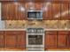 Close up of kitchen with stainless steel appliances, wood cabinets, and mosaic backsplash at 6847 W Palo Brea Ln, Peoria, AZ 85383