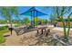 Picnic tables and playground equipment featuring shade canopies, providing an ideal outdoor space for residents at 6847 W Palo Brea Ln, Peoria, AZ 85383