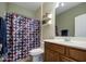 Neutral bathroom with a shower/tub combo, a wood vanity, and decorative elements at 7013 W Branham Ln, Laveen, AZ 85339