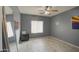 Bedroom with wood-look floors, ceiling fan, large mirror and gray walls at 7013 W Branham Ln, Laveen, AZ 85339