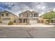 Inviting two-story home with desert landscaping, a covered front porch, and a two-car garage at 7013 W Branham Ln, Laveen, AZ 85339