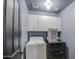 Modern laundry room featuring appliances, overhead cabinets, and a gray accent wall at 7013 W Branham Ln, Laveen, AZ 85339