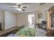 A cozy Main bedroom featuring a ceiling fan, desk, and adjoining bathroom at 7013 W Branham Ln, Laveen, AZ 85339