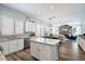 Open concept kitchen with white cabinets, stainless steel appliances, a breakfast bar and views to the living space at 7161 W Saddlehorn Rd, Peoria, AZ 85383