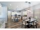 Bright open-concept kitchen with white cabinets, a breakfast bar, and modern light fixtures over the dining table at 7161 W Saddlehorn Rd, Peoria, AZ 85383