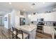 Modern kitchen with stainless steel appliances, white cabinets, a marble island, and a breakfast bar with seating at 7161 W Saddlehorn Rd, Peoria, AZ 85383