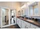 Elegant bathroom with double sinks, granite countertops, and a glass-enclosed shower at 7161 W Saddlehorn Rd, Peoria, AZ 85383