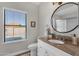 Well-lit bathroom featuring granite countertop vanity, window and a round mirror at 850 E Vaughn Ave, Gilbert, AZ 85234