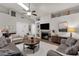 Open-concept living room with a cozy fireplace, ceiling fan and neutral palette at 850 E Vaughn Ave, Gilbert, AZ 85234